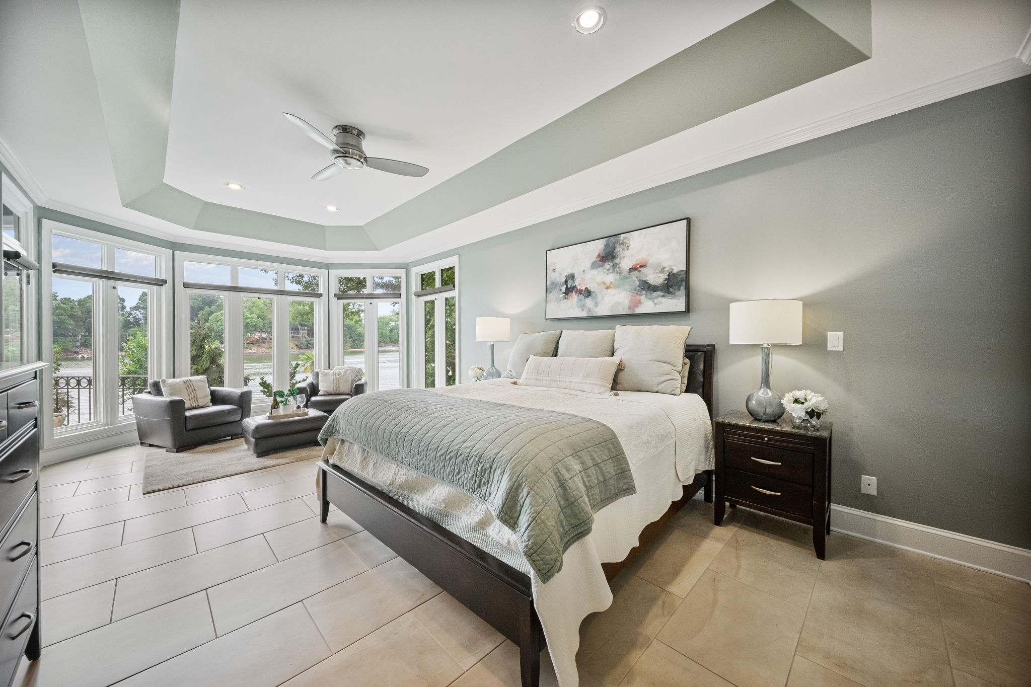 Lakeside primary suite with tray ceiling and water views